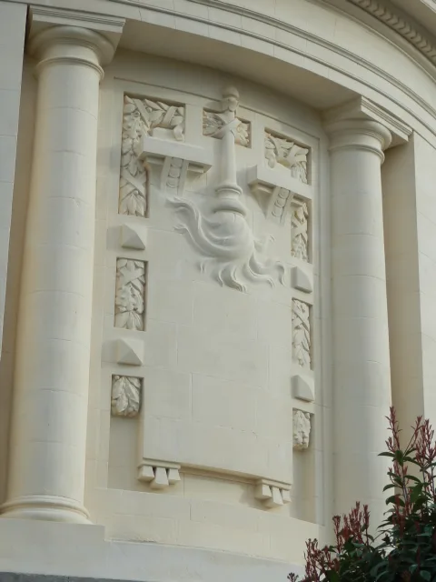 Détail de la façade rénové : un flambeau inversé, symbole de la vie qui s'éteint
