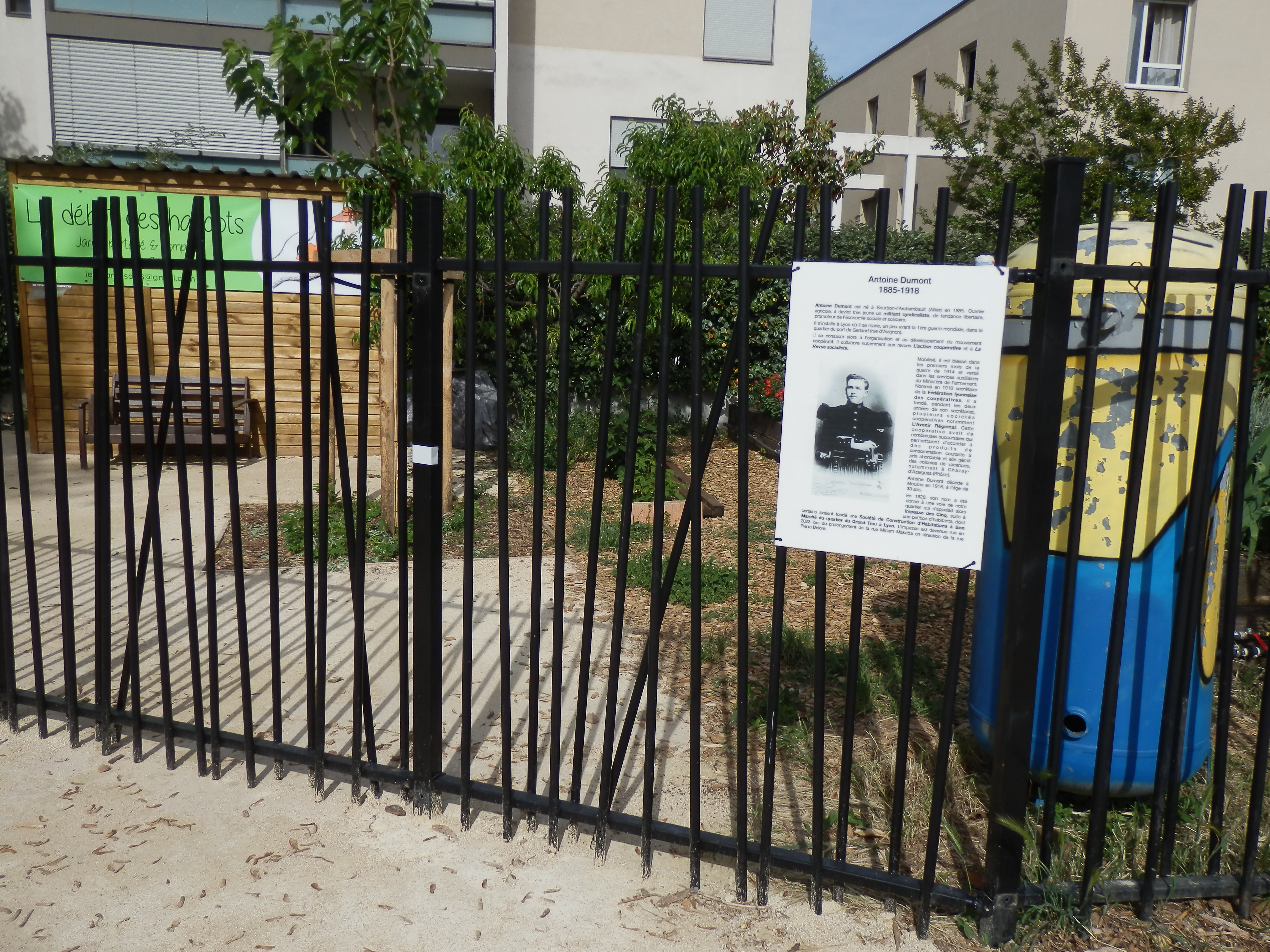 Une plaque dédiée à Antoine Dumont sur la grille du jardin partagé